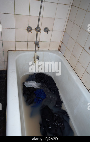 Roba da lavare in acqua sporca in un bagno di essere lavato in una corsa verso il basso il bagno Foto Stock