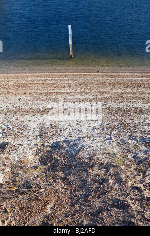 La mancanza di acqua. Una diga con livello acqua molto basso. Precedente livello di acqua segni sono visibili sulle rive della diga. Foto Stock