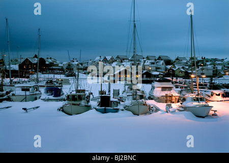 Boat Harbour sotto la neve in inverno crepuscolo Scandinavia Svezia Hönö isola. Foto Stock