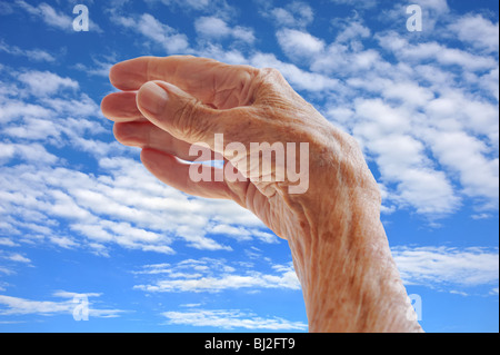 Senior donna di mano sul cielo Foto Stock