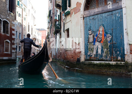 Gondola passando da graffiti lungo un piccolo canale a Venezia, Italia Foto Stock