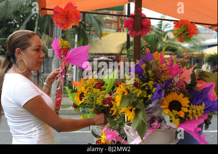 Signora che vendono fiori a fiori colorati in stallo nella piccola città Sabaneta, Medellin. Foto Stock