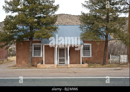 Una vecchia casa adobe ancora si affaccia sulla strada principale di Billy the Kid's wild west town di Lincoln, Nuovo Messico. Foto Stock