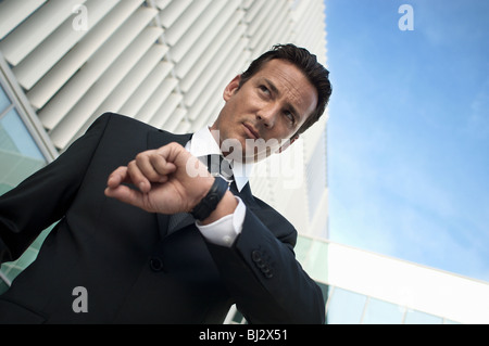 Imprenditore tenere il tempo di guardare Foto Stock