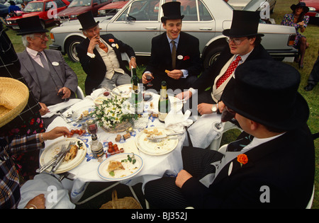 Gruppo di facoltosi Ascot race frequentatori godetevi un boozy picnic in un parcheggio auto al di fuori del famoso Racecourse Foto Stock