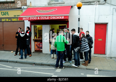 I giovani tifosi di calcio dell'Arsenal fuori del negozio di hot dog café Benwell Road Holloway Londra Inghilterra Gran Bretagna Foto Stock