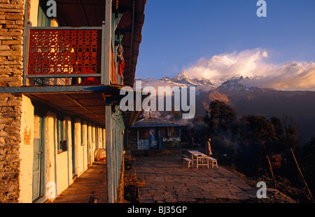 Trekker fuoriesce dalla camera di questo lodge in Nepal per stare fuori fissando Himalayan spettacolare panorama delle montagne. Foto Stock