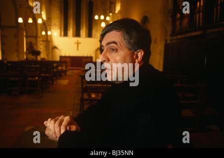 Padre Peter Geldard siede nel suo ex chiesa anglicana vicino a Faversham. Foto Stock