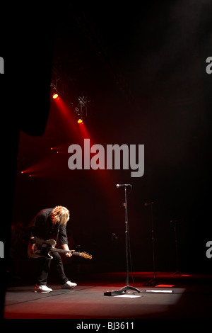 Il chitarrista Rick Parfitt del British rock and roll band Status Quo reclina il capo mentre si gioca il suo strumento elettrico sul palco Foto Stock