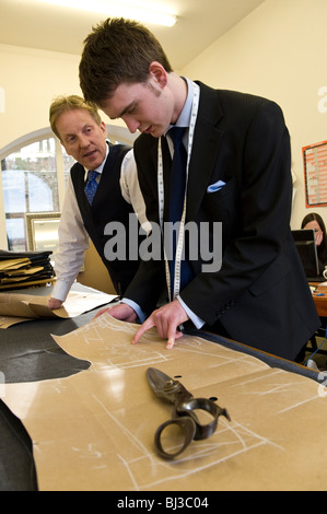 Maestro sarto Thomas Mahon istruire il suo nuovo apprendista nel commercio di sartoria presso la sua base di Carlisle Warwick Hall, Cumbra Regno Unito Foto Stock