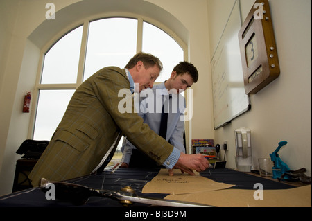 Maestro sarto Thomas Mahon istruire il suo nuovo apprendista nel commercio di sartoria presso la sua base di Carlisle Warwick Hall, Cumbra Regno Unito Foto Stock