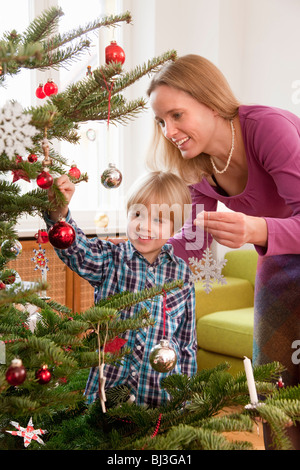 Madre e figlio decorare albero di natale Foto Stock