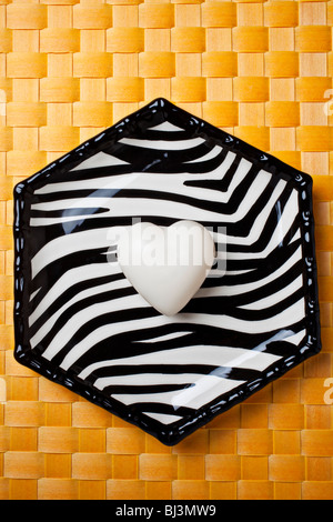 Bianco a forma di cuore barra di sapone sulla piastra a strisce Foto Stock