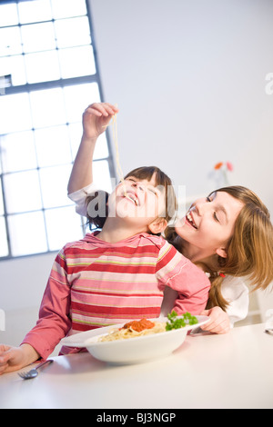Due ragazze mangiare spaghetti insieme Foto Stock