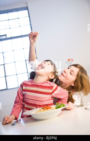 Due ragazze mangiare spaghetti insieme Foto Stock