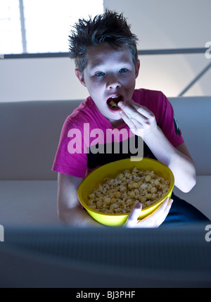 Ragazzo con popcorn guardando la televisione Foto Stock