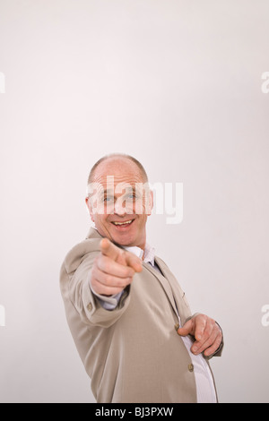 Un uomo indica il suo dito indice sulla parte anteriore, ridendo Foto Stock