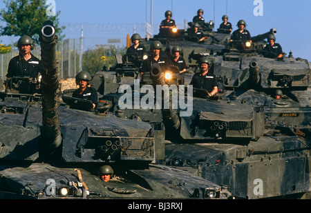 Disposto su una collina con i loro barili rivolto verso l'alto e luci incandescente, sono alterate Challenger 1 equipaggi del serbatoio Foto Stock