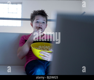 Ragazzo con popcorn guardando la televisione Foto Stock