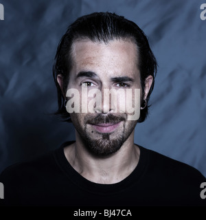 Urbano caucasico elegante giovane con orecchi perforati e piercing ritratto in studio Foto Stock