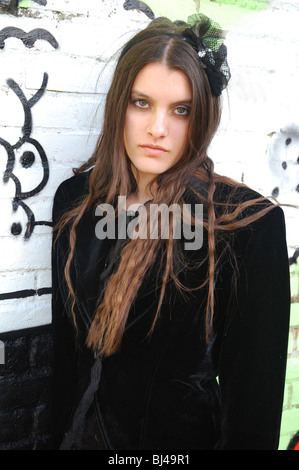 Giovane donna di goth in posa di fronte di graffiti Foto Stock