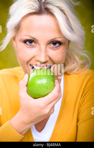 Giovane donna di mordere in apple Foto Stock