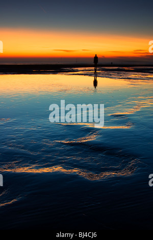 Colouful tramonto a Crosby beach, con uno di Anthony Gormly statue Foto Stock