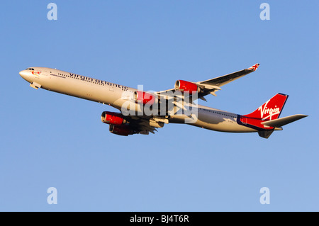 Airbus A340 azionato da Virgin Atlantic arrampicata fuori dal decollo all'Aeroporto di Londra Heathrow Foto Stock