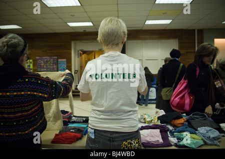 Un volontario mette fuori i vestiti in un libero fermata 'N' evento Swap in Jackson Heights quartiere di Queens a New York Foto Stock