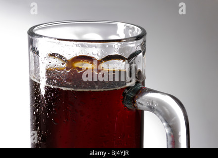 Bicchiere di birra scura su sfondo grigio Foto Stock