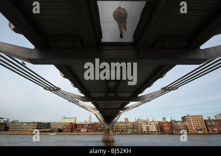 London Millennium Bridge di Londra Inghilterra Regno unito con un uomo attraversando visto da sotto Foto Stock