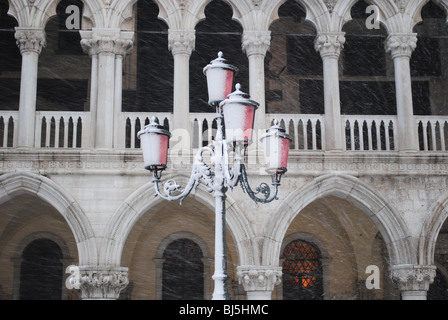 Tempesta di neve e rosa luce di strada di fronte al Palazzo Ducale, Piazza San Marco, Venezia, Italia Foto Stock