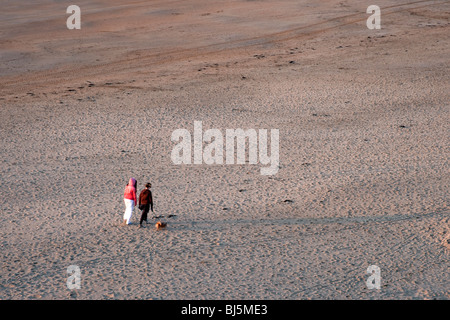 Due donne con il cane a camminare sulla spiaggia Ballybunnion, Irlanda Foto Stock