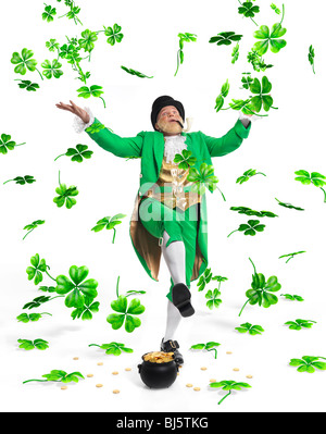 Leprechaun in bright green vestiti con un vaso pieno d'oro gettando shamrock foglie fino nell'aria. Isolato su sfondo bianco. Foto Stock