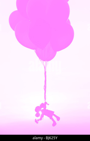 Rag Doll tenuta su palloni di elio si allontanano. Silhouette rosa concetto Foto Stock