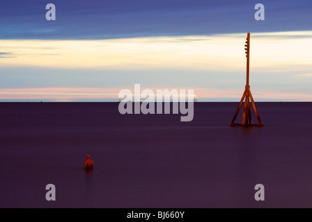 Colouful tramonto a Crosby beach, con uno di Anthony Gormly statue Foto Stock