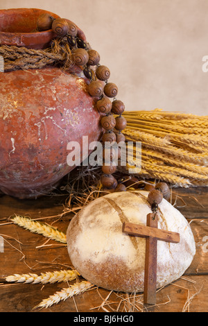 Antiquariato brocca vino, croce e rustico della pagnotta di pane come simboli cristiani della fede Foto Stock