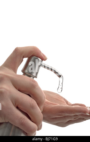 Una donna di pompaggio detergente per mano/sanitizer su bianco Foto Stock