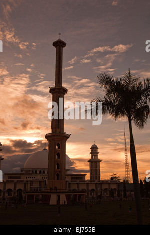 Indonesia Sulawesi, Sengkang, alto minareto della moschea principale di alta sopra la città skyline al tramonto Foto Stock