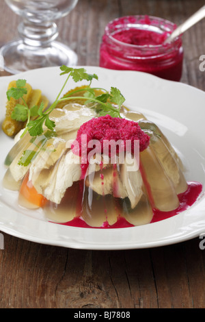 Aspic con carne di pollo e carote servita su piastra bianca Foto Stock