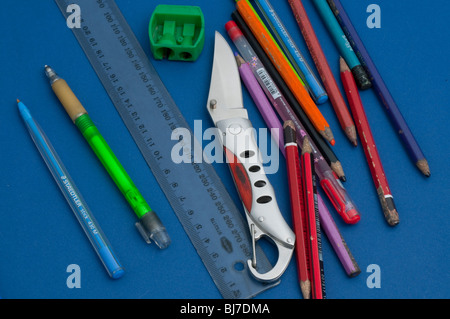 Il coltello tra scuola matite e attrezzature Foto Stock