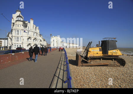 Una scavatrice - utilizzato per ridistribuire il mare-difesa shingle - sulla spiaggia di Eastbourne. Foto Stock