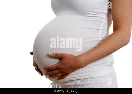 8 mese di gravidanza della donna di 30 anni di età tenendo baby bump Foto Stock