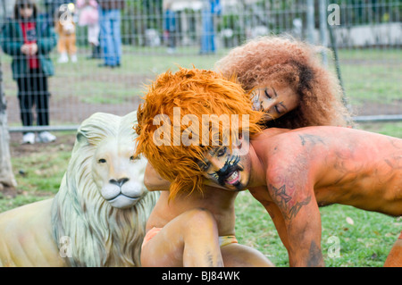 L uomo e la donna in Lion e costumi leonessa e bodypaint in una gabbia Foto Stock