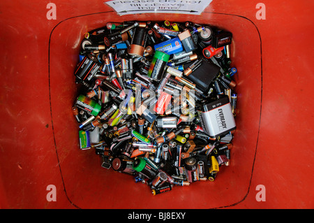 Batterie per uso domestico attendono la raccolta e il riciclaggio in questo scomparto di rosso Foto Stock