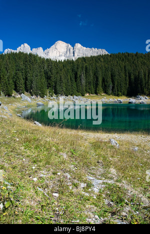 La colorata montagna lago di Carezza ai piedi del Gruppo del Latemar delle Dolomiti in Italia. Foto Stock