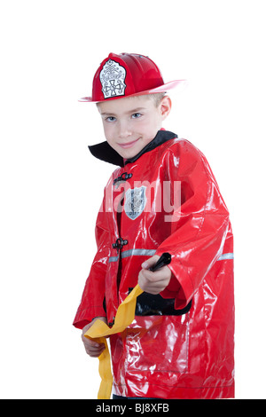 Giovane ragazzo in riproduzione vestito in costume da vigile del fuoco. Isolato. Foto Stock