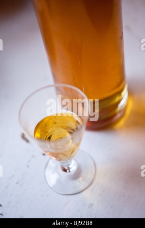 Schnaps svedese in un piccolo bicchiere su un vecchio tavolo Foto Stock