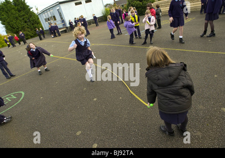 Saltando, scuola tradizionale parco giochi gioco che viene giocato sul schoolyard di una scuola primaria in Wales UK Foto Stock