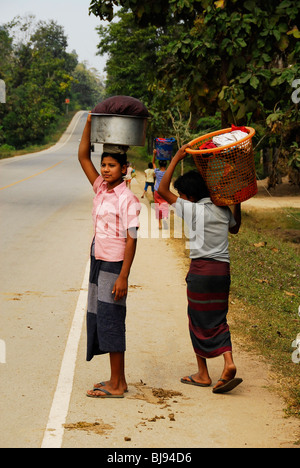 Karen ladies attraversamento di strada con il loro lavaggio, il campo per rifugiati di Mae La,(thai confine birmano) ,a nord di Mae Sot,thailandia Foto Stock